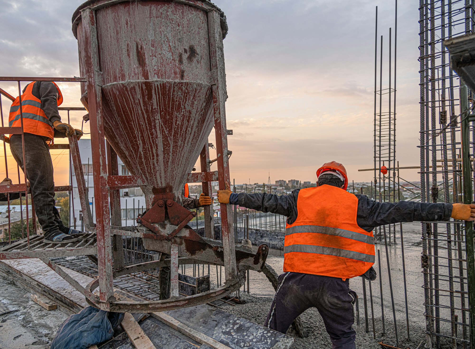 Workers on a building infrastructure roof with machinery and tools